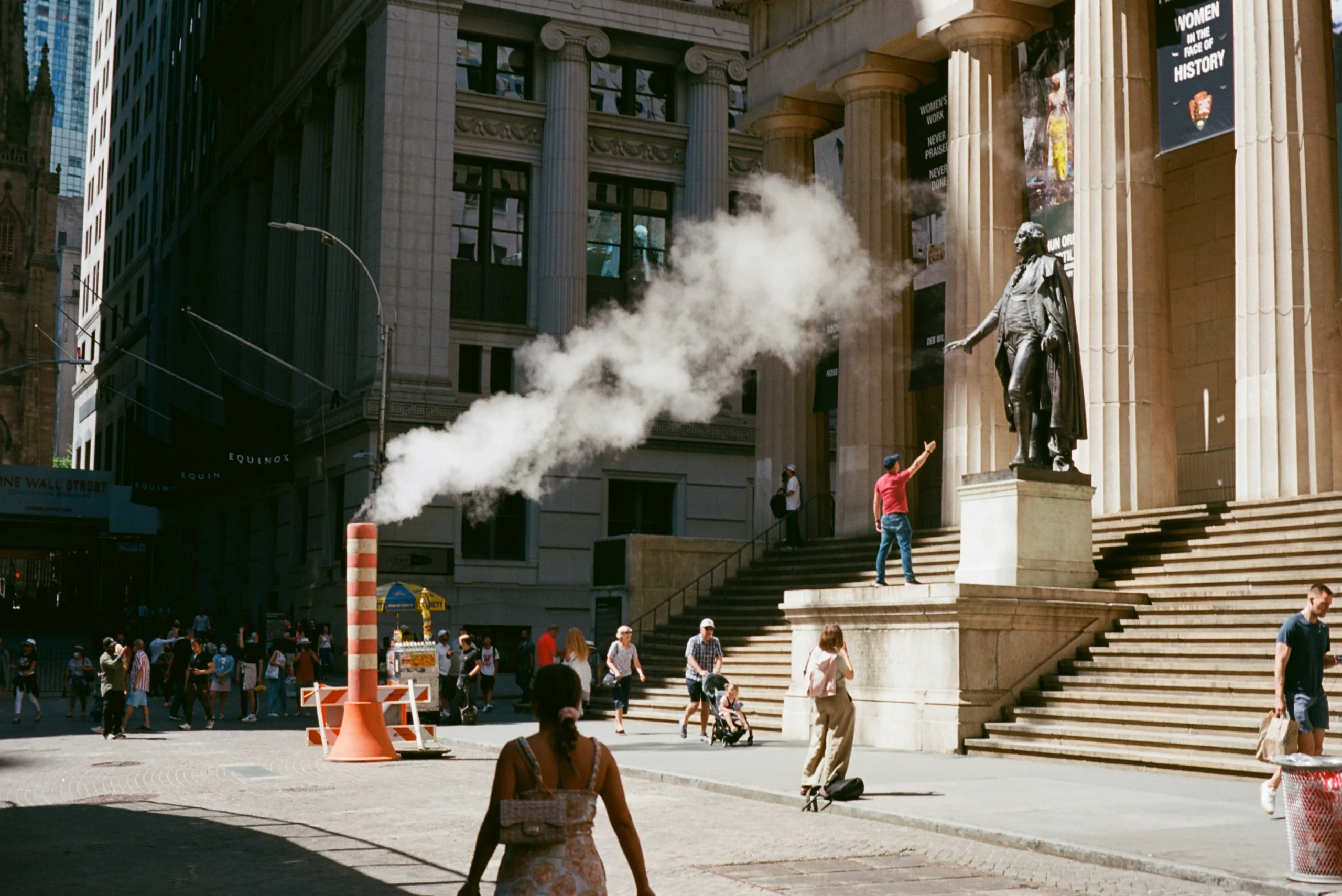 Woman walking past Federal Hall in Wall Street NYC